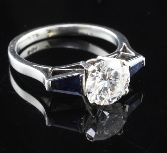 A modern platinum and single stone diamond ring with trapezoid cut sapphire set shoulders, size N.